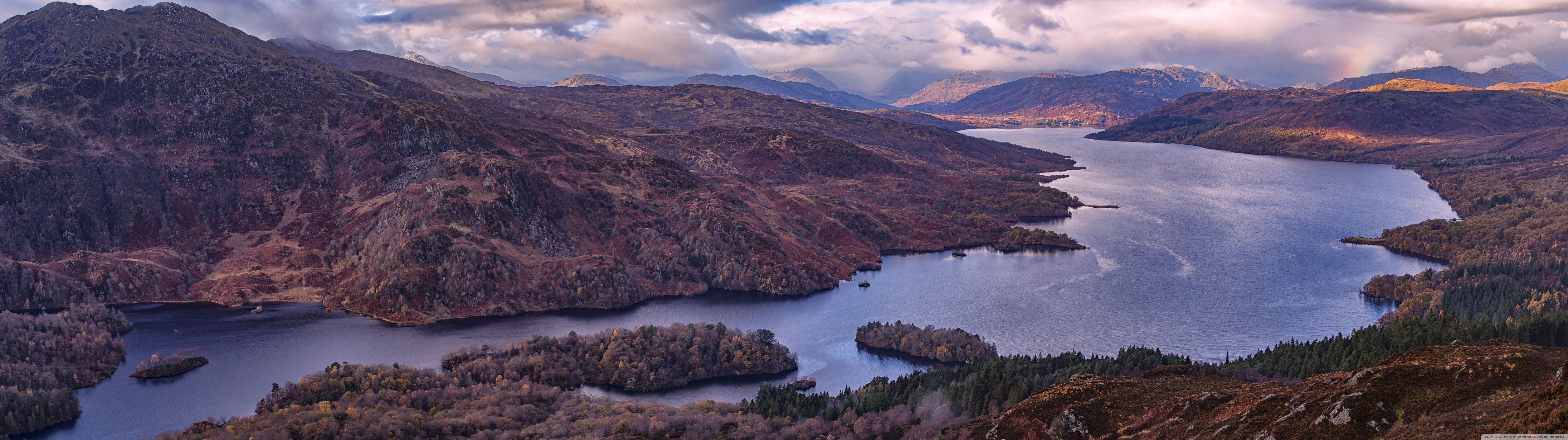 panoramic_view_of_a_mountain_lake-wallpaper-7108x1999|690x193